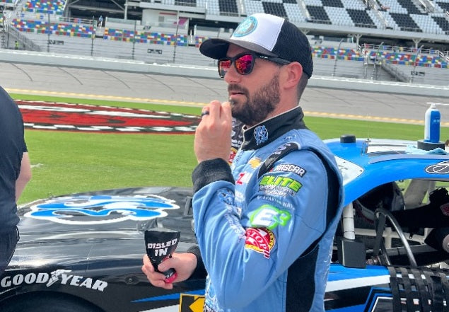 NASCAR driver Jeremy Clements using Dialed In Focus and Energy Gum beside his race car at Daytona International Speedway